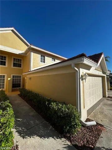 View of home's exterior featuring stucco siding, a garage, and driveway