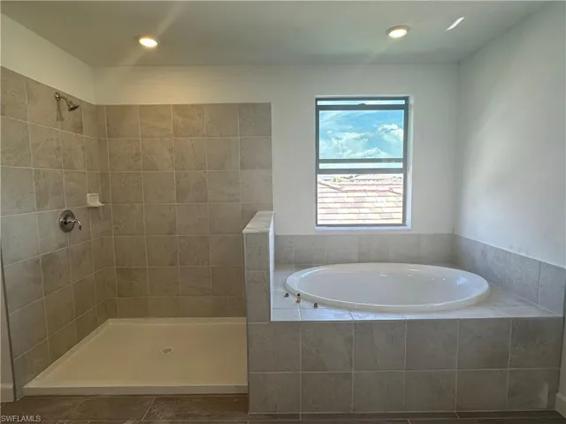 Bathroom featuring tile floors and plus walk in shower