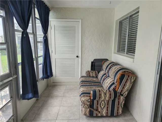 Sunroom featuring a textured wall and tile patterned flooring