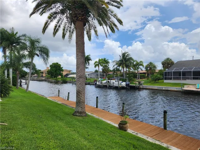 Dock area featuring a yard, a water view, and a residential view