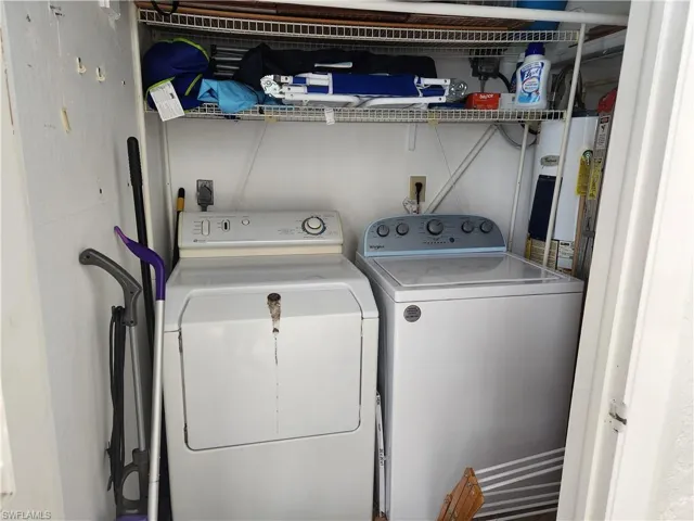 Laundry area with water heater and washing machine and clothes dryer