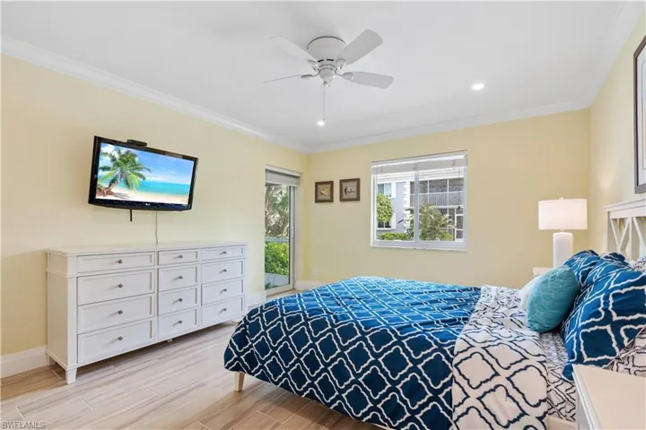Bedroom with ornamental molding, light hardwood / wood-style flooring, and ceiling fan