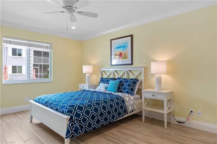 Bedroom with wood-type flooring, ceiling fan, and crown molding