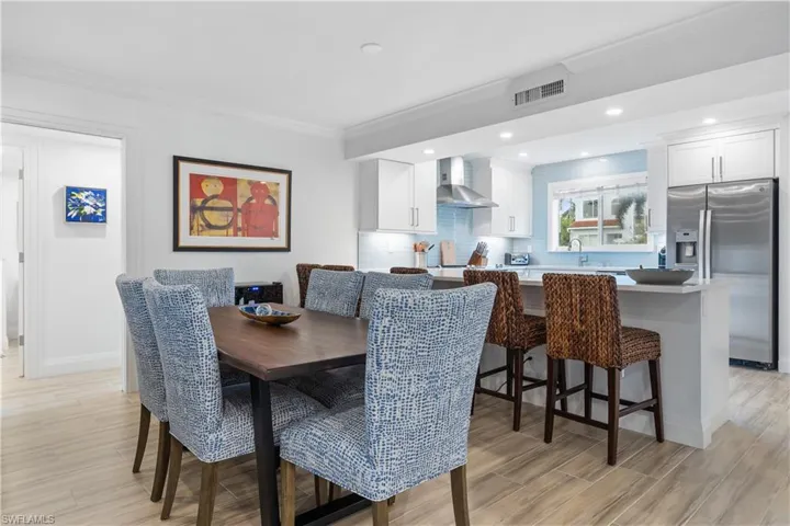 Dining space featuring sink, crown molding, and light hardwood / wood-style flooring