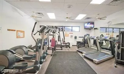 Gym featuring a ceiling fan and a drop ceiling