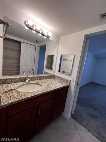 Bathroom featuring light carpet, vanity, and light tile patterned flooring