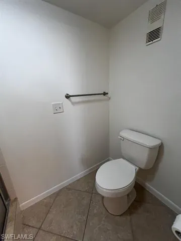 Bathroom with toilet and light tile patterned flooring