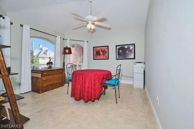 Living room with arched walkways, recessed lighting, ceiling fan, lofted ceiling, and light tile patterned flooring
