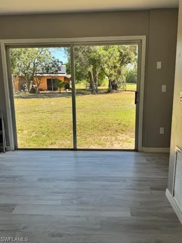 Entryway featuring visible vents, baseboards, and wood finished floors