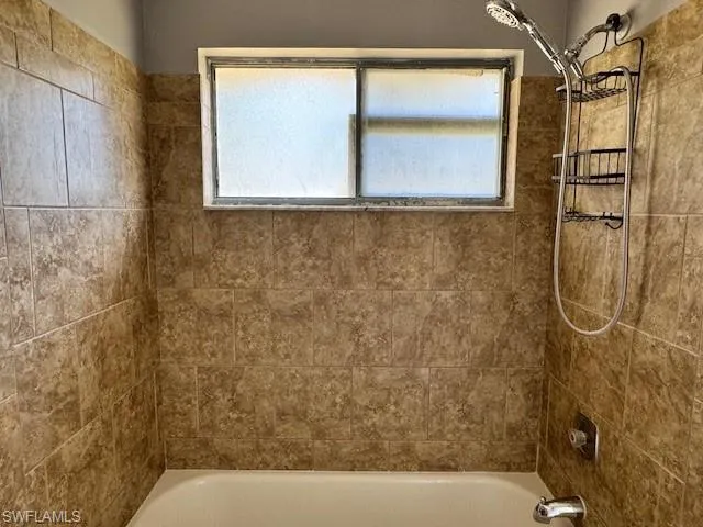 Bathroom with shower / bath combination and a healthy amount of sunlight
