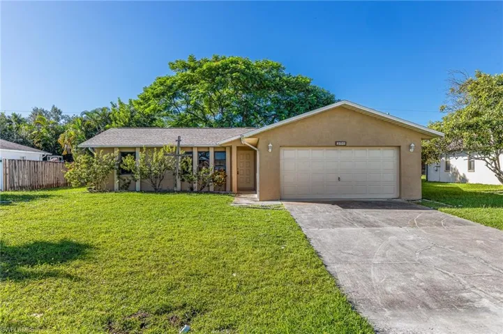 Single story home with stucco siding, concrete driveway, and a garage