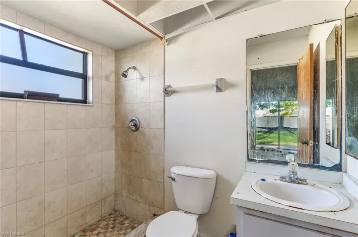 Bathroom featuring healthy amount of natural light, vanity, and a shower stall