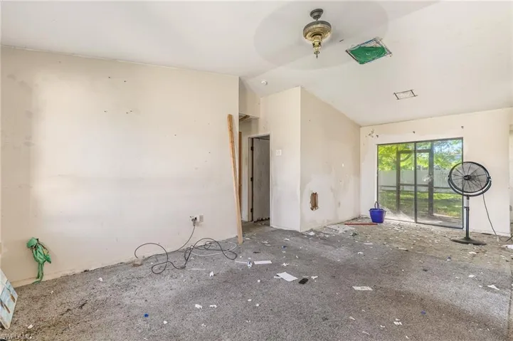 Unfurnished living room featuring vaulted ceiling