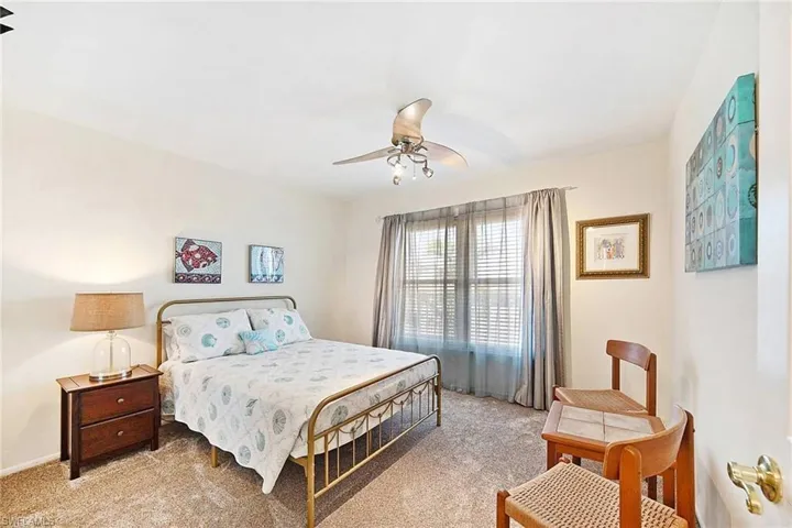 Carpeted bedroom featuring a ceiling fan