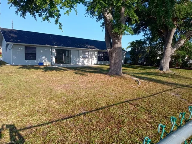 Rear exterior featuring a patio, sliding glass doors, and a dark shingle roof