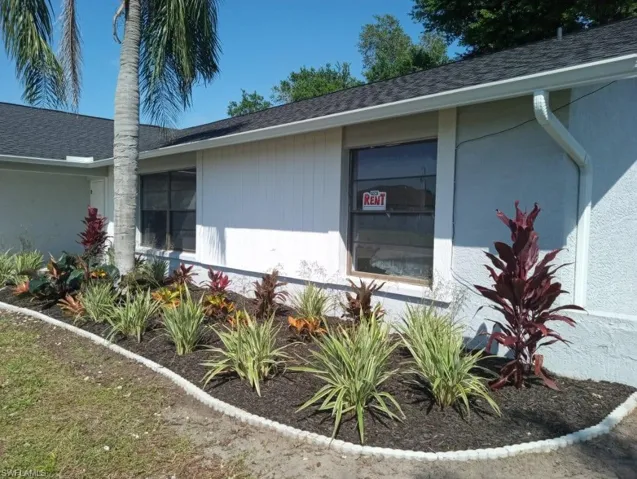 Front exterior featuring white siding, dark shingle roofing, and white gutters