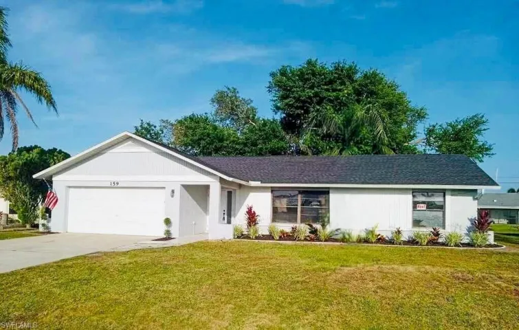 Single-story residence featuring a white exterior, attached garage, and dark shingle roof