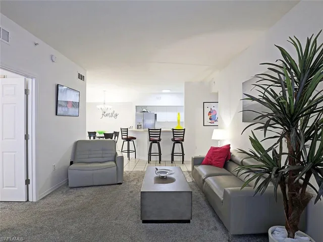 Living area featuring light carpet and a chandelier