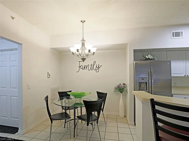 Dining room with light tile patterned floors and a chandelier