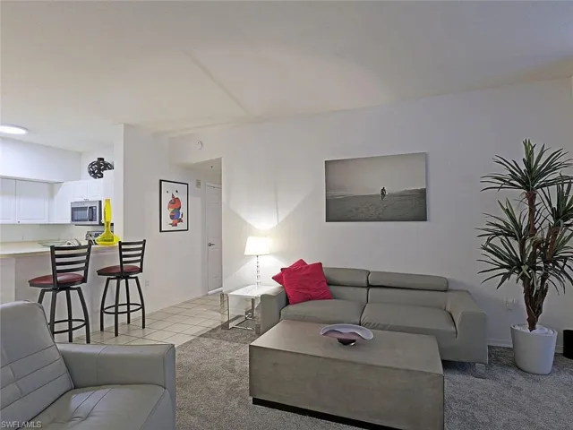 Living area with light colored carpet and baseboards
