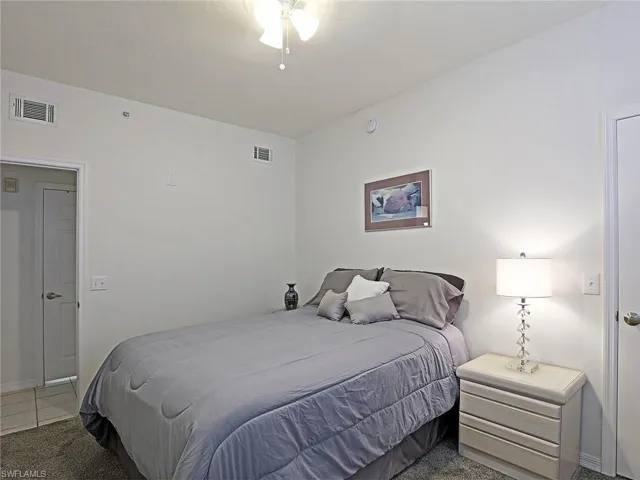Bedroom featuring light tile patterned floors and light colored carpet