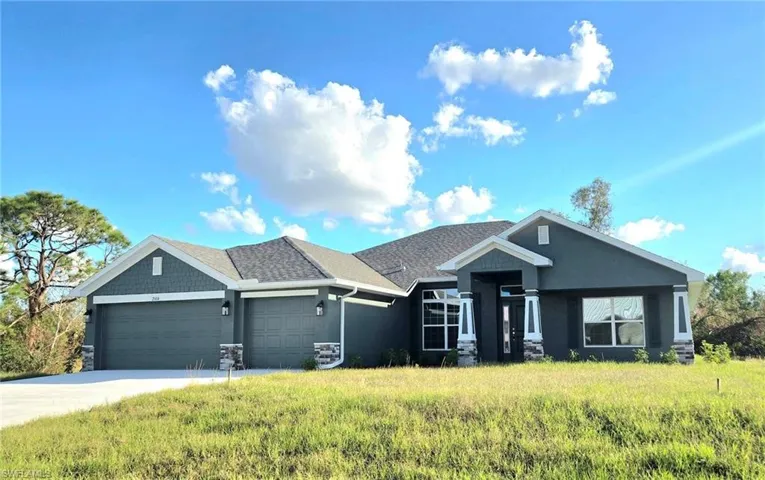 View of front of home featuring a front yard and a garage