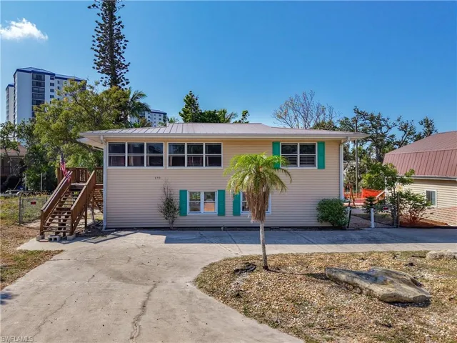 View of front of home featuring stairs and curved driveway