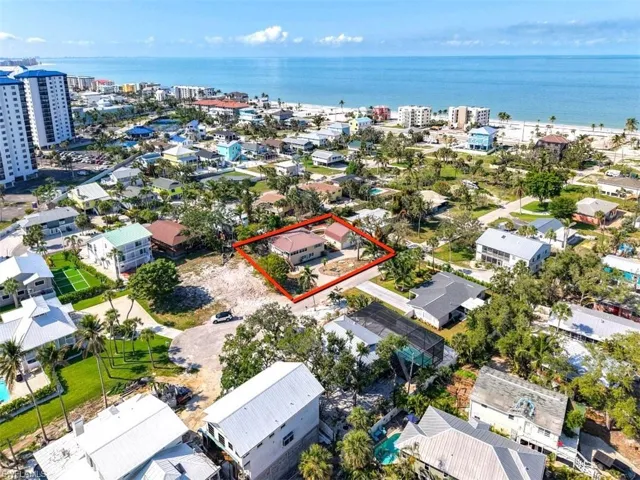 Aerial view of property and surrounding area with property parcel outlined and a large body of water