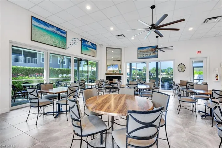 Dining room featuring ceiling fan, a high drop ceiling, and a fireplace