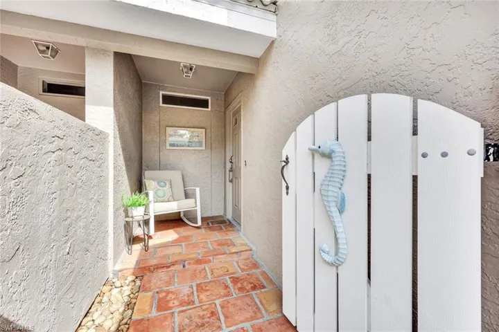 View of exterior entry featuring a gate and stucco siding