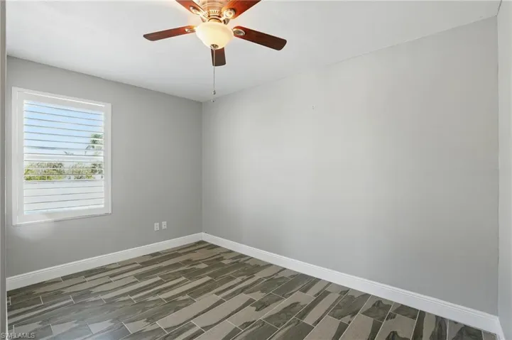 Spare room with ceiling fan and wood finished floors- Virtually Enhanced