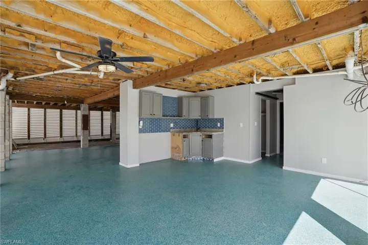 Unfurnished living room featuring ceiling fan and light speckled floor- Virtually Enhanced
