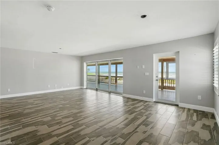 Spare room featuring a smoke detector and wood tiled floors- Virtually Enhanced