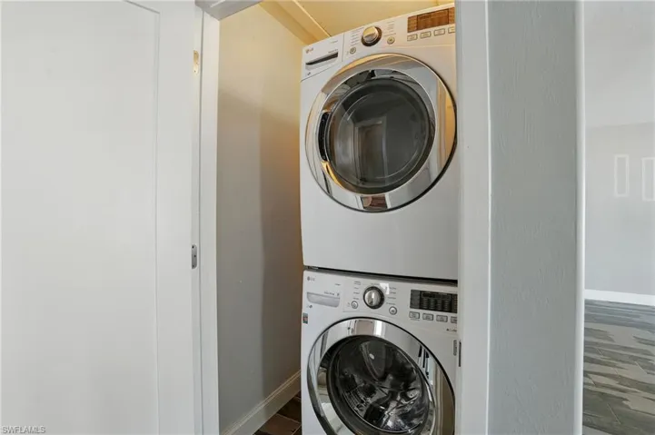Laundry room featuring estacked washer and dryer and baseboards- Virtually Enhanced