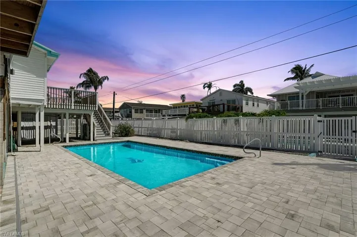 Pool at dusk with stairway and a patio- Virtually Enhanced