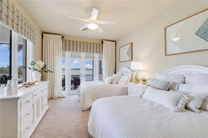 Carpeted bedroom featuring multiple windows, french doors, access to exterior, and ceiling fan