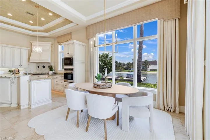 Dining space with a high ceiling, a tray ceiling, and crown molding