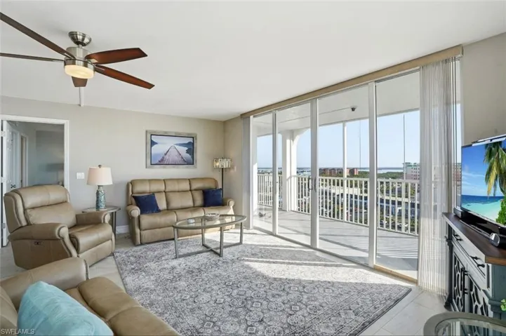 Living room featuring a ceiling fan and floor to ceiling windows - Virtually Edited Image