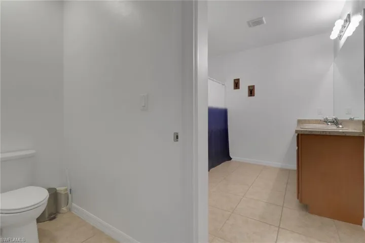 Bathroom featuring toilet, tile patterned floors, and vanity