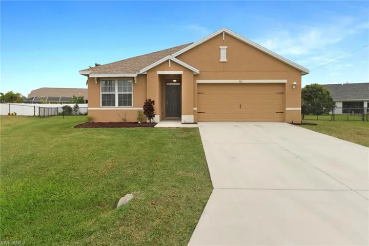 Ranch-style home featuring a front lawn and a garage