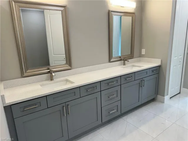 Bathroom featuring dual bowl vanity and tile patterned floors