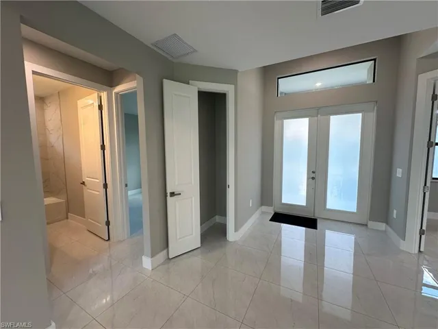 Tiled entryway featuring french doors