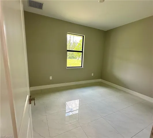 Spare room with light tile patterned flooring