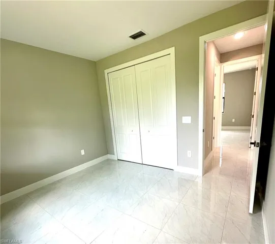 Unfurnished bedroom with a closet and light tile patterned floors