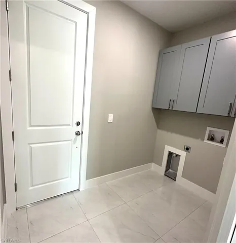 Laundry room with electric dryer hookup, cabinets, washer hookup, and light tile patterned floors