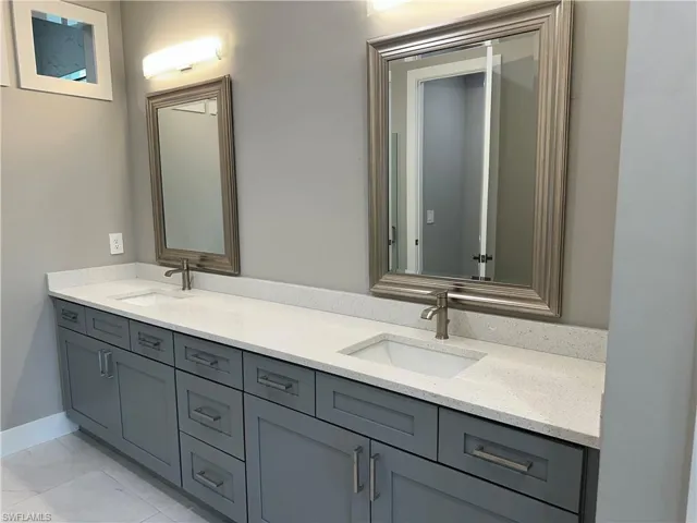 Bathroom with double sink vanity and tile patterned floors