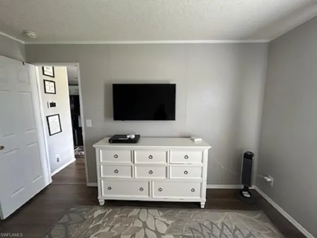 Bedroom featuring a textured ceiling and dark wood-type flooring