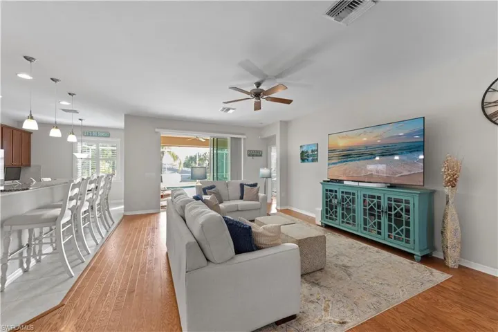 Living area featuring ceiling fan, light wood finished floors, and recessed lighting