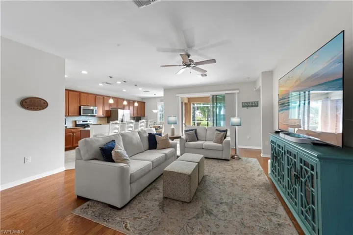 Living room featuring wood finished floors, ceiling fan, and recessed lighting