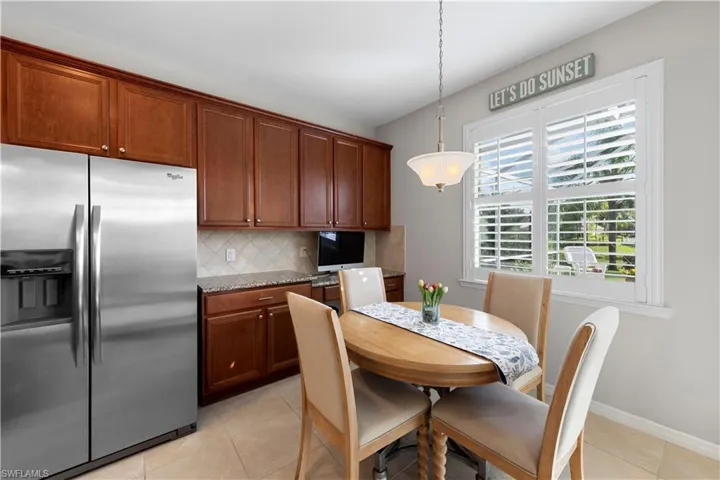 Dining space with light tile patterned flooring and baseboards